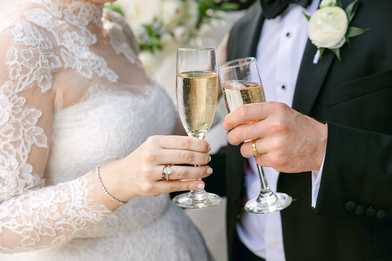 WPC Wedding Catering Bride and groom toasting with champagne flutes at their wedding reception, showcasing a lace bridal gown and diamond engagement ring